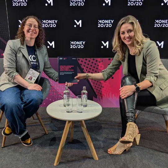 A picture of a representative from FXC Intelligence and one from Money 20/20 holding the report